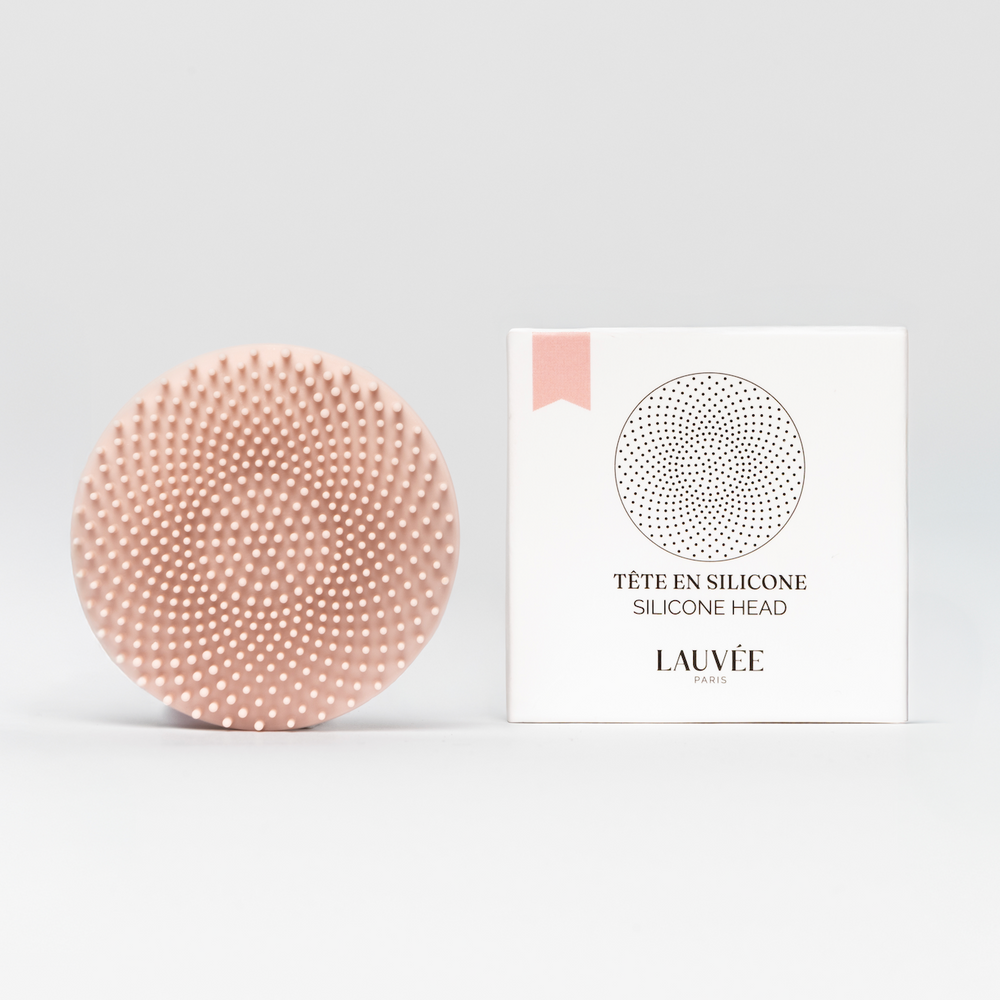 Tête de rechange en silicone rose Lauvée posée à côté de son boîtier blanc portant la mention « Tête en silicone / Silicone Head » et le logo Lauvée, sur fond blanc.