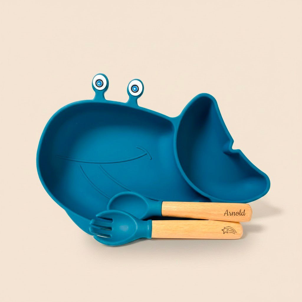 Assiette bleue en forme de baleine avec une fourchette et une cuillère à manches gravés