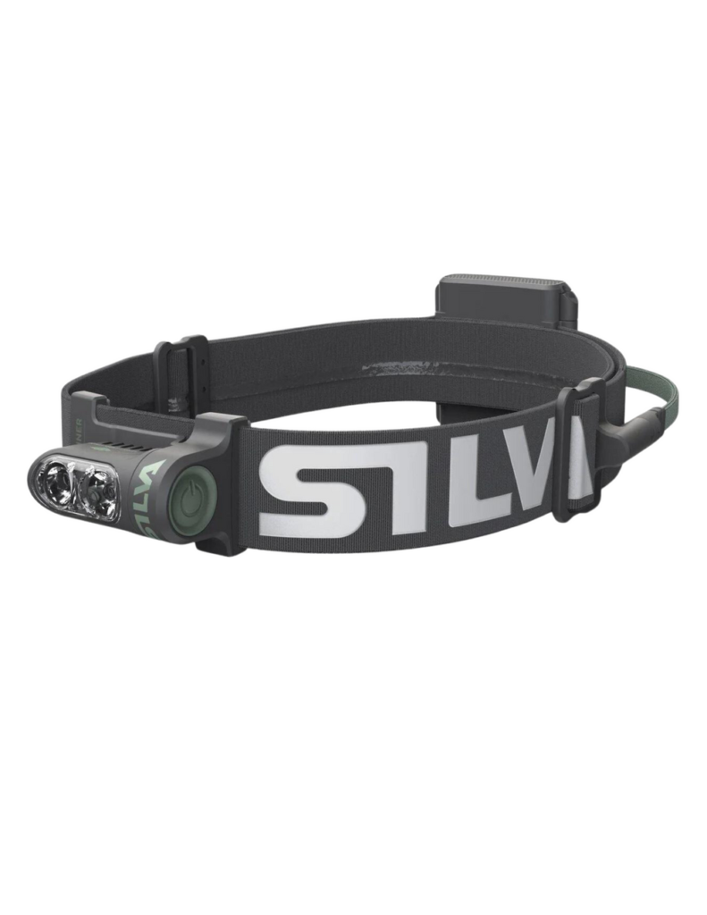 Vue trois quarts de la lampe frontale Silva Trail Runner Free 2 Hybrid sur fond blanc, montrant le bandeau gris avec logo SILVA et le bloc optique frontal avec ses trois LEDs et bouton d'allumage vert.
