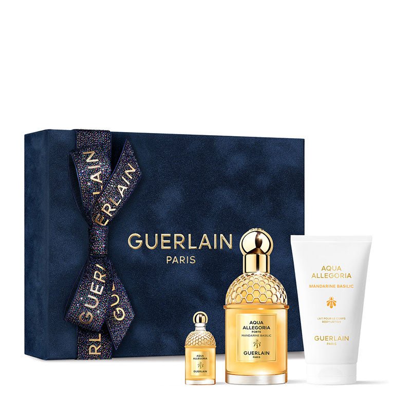 Coffret Guerlain bleu nuit noué d'un ruban scintillant, présentant un grand flacon Aqua Allegoria Mandarine Basilic Forte, un format miniature et un lait pour le corps, sur fond blanc.