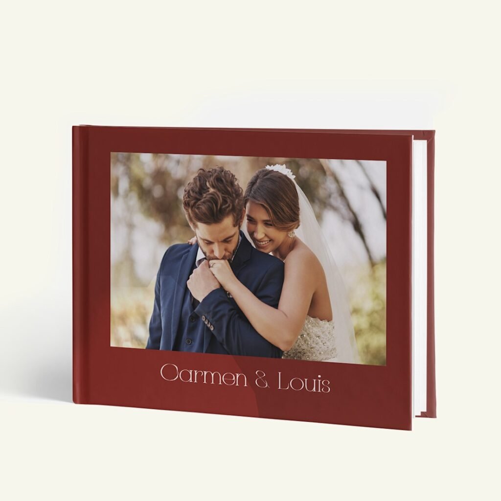 Livre photo à couverture bordeaux avec la photographie d'un couple et deux prénoms